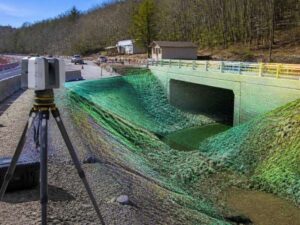 Tripod-mounted LiDAR scanner mapping a culvert, bridge, and drainage channel for infrastructure planning in Hialeah, Florida.