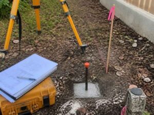 Newly set property survey monument with boundary stakes and field equipment in Hialeah, Florida. 