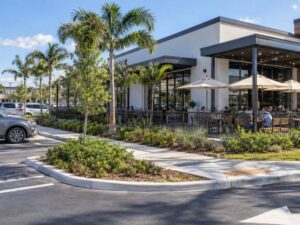 Land surveyor documenting a restaurant patio beside parking and sidewalks for a plat of survey in Hialeah, Florida.